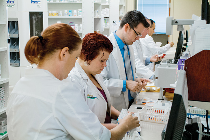 Atlantic Apothecary staffers work preparing prescriptions for customers. They have 15,000 names in their database, even though they are operating in a town of 10,960. (Photography by Brian Harvath)